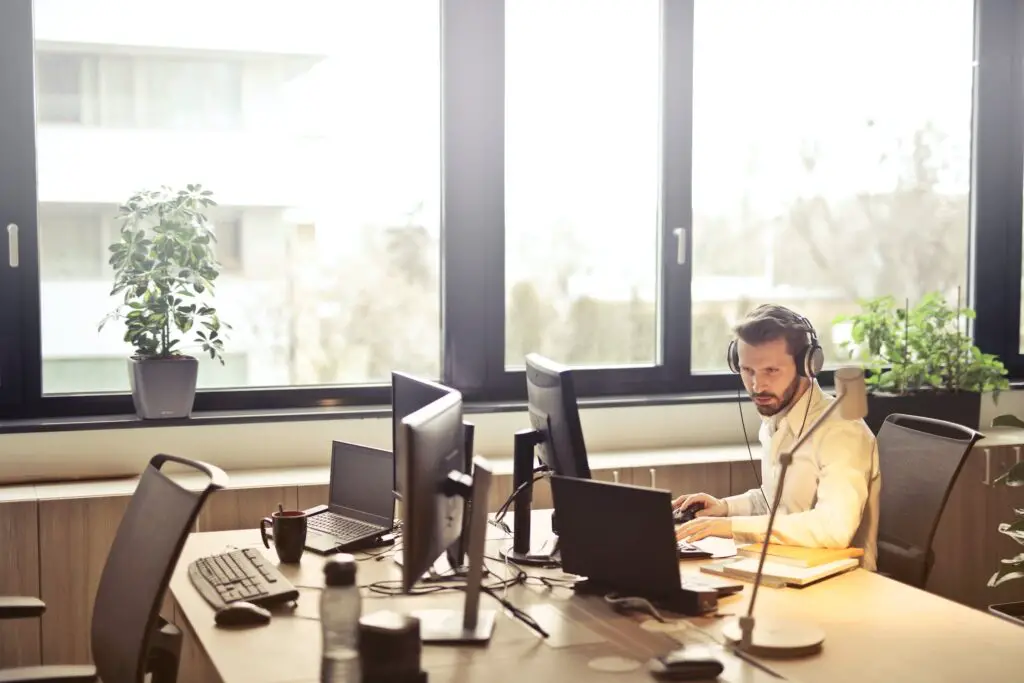 Man With Headphone Facing Computer Monitor